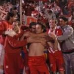 Futbolista defensor argentino en un partido nocturno dentro de un estadio iluminado