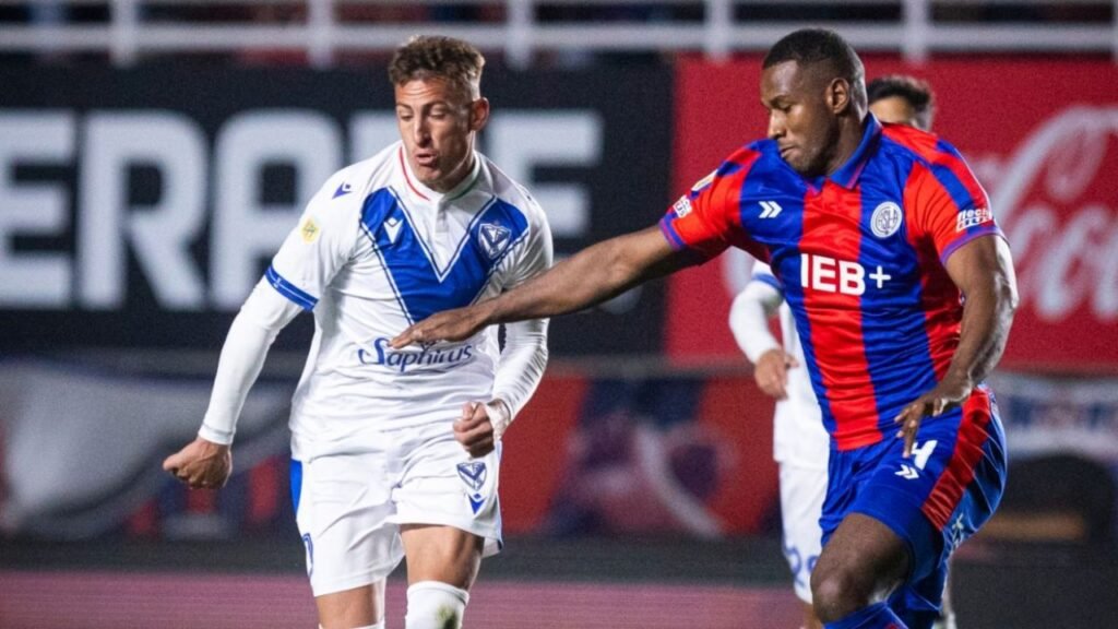 Jugadores de San Lorenzo y Vélez disputando la pelota en un partido